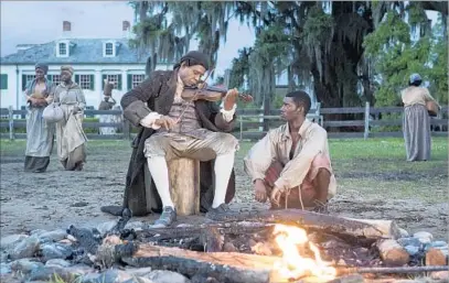  ?? Steve Dietl A+E Networks ?? FIDDLER (Forest Whitaker) plays a tune for Kunta Kinte (Malachi Kirby) in History’s “reimaginin­g” of “Roots.”