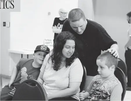  ?? COLIN PERKEL / THE CANADIAN PRESS ?? Former U.S. Marine Cpl. Dean Walcott is shown with his wife and two of his Canadian-born children in Toronto. After two tours in Iraq, Walcott and his family fled to Canada. He is one of four American soldiers whose cases are due in Federal Court in September.