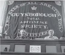  ?? AARON BESWICK ?? Jamie Grant and Mark Haynes, of the Guysboroug­h Historical Society, sit in front of one of two large silk Total Abstinence banners made by women in 1830. The society is campaignin­g to have them better preserved.