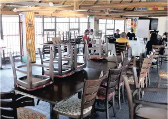  ??  ?? CHAIRS are placed on top of tables while staff hold a meeting at Sakhumzi restaurant in Soweto last month.
| SIPHIWE SIBEKO Reuters