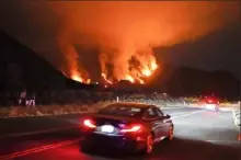  ?? Marcio Jose Sanchez/Associated Press ?? Motorists make their way along a road as the Ranch Fire burns Thursday in Azusa, Calif.