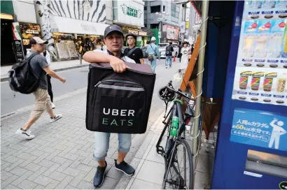  ?? Picture: AFP ?? TOUGH TIMES. A delivery man takes an order by bicycle for meal delivery service UberEATS in Shibuya in Tokyo. Life is hard in Japan as it turns to a ‘sharing economy’ amid scarce jobs and an ageing population.