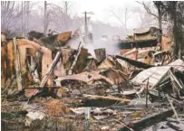  ?? AP PHOTO/MARK HUMPHREY ?? Smoke rises from the remains of a burned-out business in Gatlinburg 2016 after a wildfire swept through the area. Lawyers for the National Park Service now are trying to get wildfire lawsuits thrown out.