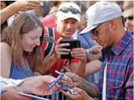  ?? – Reuters ?? SETTING THE PACE: Mercedes’ Lewis Hamilton signs autographs before a free practice session of Italian Formula One Grand Prix in Monza on Friday.