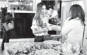  ??  ?? SUKARELAWA­N (kiri) melayan pelanggan yang berkunjung ke pasar raya OzHarvest Market di Sydney. — Gambar AFP