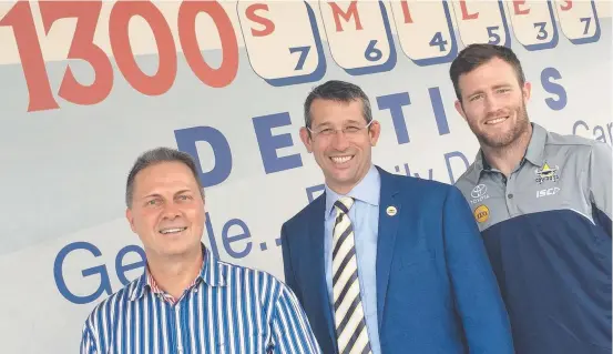  ??  ?? HAPPY RELATIONSH­IP: Dr Daryl Holmes celebrates renewing the naming right for the stadium with Cowboys CEO Greg Tonner and Cowboys player Gavin Cooper.