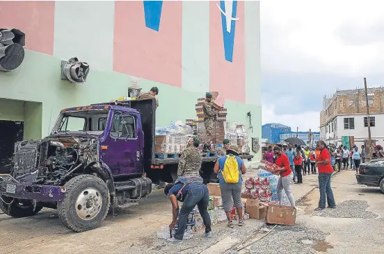  ?? Picture: PA. ?? Members of the armed forces and staff from Social Services Relief distributi­ng aid in Road Town, Tortola, BVI.