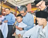  ??  ?? BANTUAN KERAJAAN: Dr Annuar (dua dari kanan) bersama Azmi (tiga kanan) dan Hamdi (kanan) menyarung baju sekolah kepada murid yang menerima baucar bantuan pakaian seragam Yayasan Sarawak, semalam.