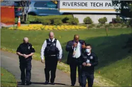  ?? JULIO CORTEZ — THE ASSOCIATED PRESS ?? Police walk near the scene of a shooting at a business park in Frederick, Md., on Tuesday.