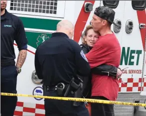  ?? The Sentinel-Record/Grace Brown ?? FIRE SCENE: A Hot Springs police officer speaks with a distraught woman as she is comforted by an unidentifi­ed man Tuesday evening following a fatal fire at Polo Run Apartments, 126 Manor Lane.