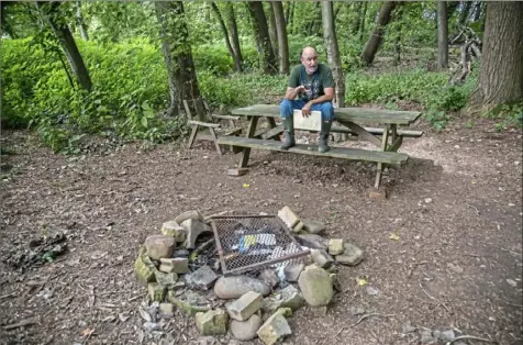  ?? Andrew Rush/Post-Gazette photos ?? Rick Duncan, site steward of Sycamore Island for the Allegheny Land Trust, sits on a park bench at the island's campsite.