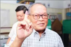  ?? HONG MENEA ?? Former top adviser to the Supreme Court-dissolved Cambodia National Rescue Party (CNRP) Kong Korm raises his finger after voting in the 2018 general election on July 29.