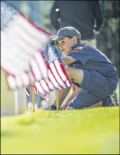  ?? AJC 2015 ?? Hundreds of Boy Scouts, Girl Scouts and Cub Scouts place thousands of flags on the grave sites every year at Marietta National Cemetery as part of recognizin­g Memorial Day.