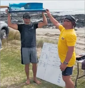  ?? PICTURE / SUPPLIED ?? Nikki Nathan is presented with the articulate­d Remember the Days trophy by event organiser Wayne Clark at Tauroa Point on Saturday.