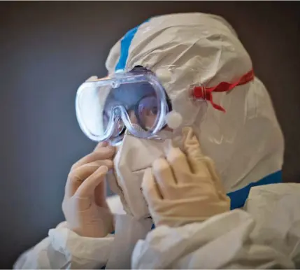  ??  ?? A member of the medical team of the Second Military Medical University puts on protective clothing at Hankou Hospital in Wuhan on 27 January, 2020.