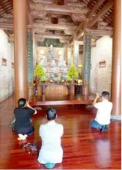  ?? ?? PLACE OF PEACE: Visitors pray inside Địa Tạng Phi Lai Pagoda.