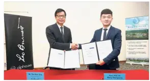  ??  ?? Tan (left) exchanges documents with Dr Wang after the signing ceremony at the university.