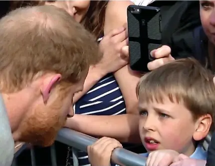  ??  ?? Face to face: The prince leans down to chat with a boy behind a crush barrier