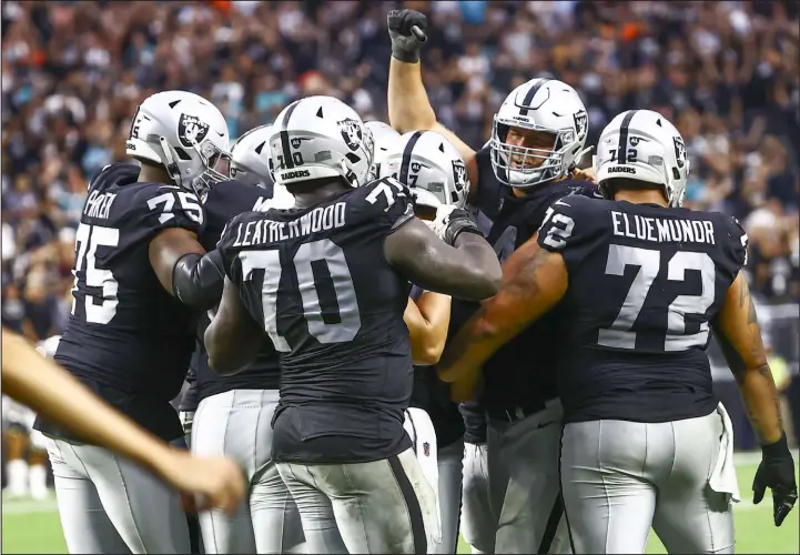  ?? Chase Stevens Las Vegas Review-journal @csstevensp­hoto ?? Teammates mob Daniel Carlson, somewhere in the middle, after his field goal in overtime beats the Miami Dolphins 31-28 on Sunday at Allegiant Stadium.