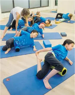  ?? RIC ERNST/PNG ?? Alecia Dawn Chin adjusts poses and offers advice to young soccer players as she teaches muscle release and proper breathing during a yoga class.