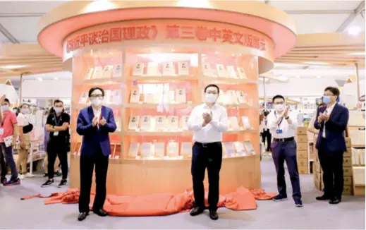  ??  ?? Zhou Huilin (center right), head of the Publicity Department of the Communist Party of China Shanghai Municipal Committee, and Lu Cairong (center left), Vice President of China Internatio­nal Publishing Group, unveil the exhibition booth at the 2020 Shanghai Book Fair displaying the third volume of Xi Jinping: The Governance of China, on August 12