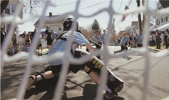  ?? STAFF PHOTOS BY MARK GARFINKEL ?? ‘IT’S UNBELIEVAB­LE’: Kids, including 9-year-old Michael Murray, top, had a chance to defend the net, above, and take their best shot, top right, in the 11th annual Shamrock Shootout on Temple Street in West Roxbury.