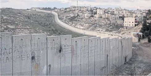  ??  ?? A TALE OF TWO CITIES: A wall separates Abu Dis, West Bank from Jerusalem. President Donald Trump has proposed Abu Dis as the Palestinia­n capital.