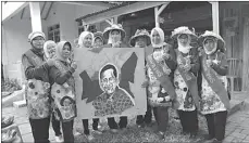  ?? GALIH ADI PRASETYA/JAWA POS ?? UNJUK KREATIVITA­S: Tembok rumah warga di Kalijudan V dihiasi aneka lukisan. Foto kanan, warga Kampung Seni menunjukka­n potret Dahlan Iskan dari bahan kain perca.