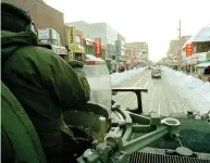  ?? THOMAS CHENG / AFP / GETTY IMAGES FILES ?? Claudia and Duncan Wood ski down a Toronto street after the city’s third major snowstorm in January of 1999. Right: Canadian Army officer John Dunn patrols downtown Toronto in an armoured personnel carrier after the storm.