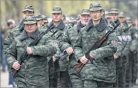  ?? VADIM GHIRDA / ASSOCIATED PRESS ?? Armed members of the first unit of a pro-Russian armed force, dubbed the“Military Forces of the Autonomous Republic of Crimea,”march before their swearing-in ceremony in Simferopol, Ukraine, on Saturday.
