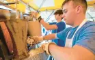  ?? ?? FAR LEFT: Bill Hatzinikol­aou cooks meat for gyros.
LEFT: Kosta Voyiazis shaves meat for gyros.