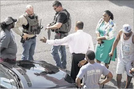  ?? BRAD VEST/THE COMMERCIAL APPEAL ?? U.S. Marshals talk with bystanders outside the Clifford Davis/Odell Horton Federal Building in Downtown after Tremaine Wilbourn, joined by his family, surrendere­d there Monday afternoon in the Saturday night slaying of Memphis police officer Sean Bolton.