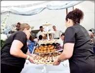  ?? (The New York Times/Gabriela Herman) ?? Workers with Buckley’s Gourmet Catering display desserts during a wedding.