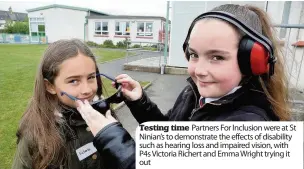  ??  ?? Testing time Partners For Inclusion were at St Ninian’s to demonstrat­e the effects of disability such as hearing loss and impaired vision, with P4s Victoria Richert and Emma Wright trying it out