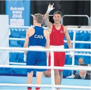  ??  ?? Boxer Atichai Phoemsap, right, celebrates his win over Canada’s Spencer Wilcox.