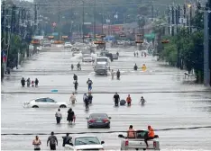  ?? Fotos: Mark Mulligan, dpa/Thomas B. Shea, afp ?? Die texanische Metropole Houston steht unter Wasser: Zwei Männer bahnen sich mit dem Schlauchbo­ot den Weg durch die Stadt (links). Das Foto rechts zeigt einen Blick in die Telephone Road, eine Straße etwas südlich des Houstoner Zentrums.