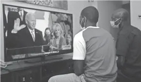  ?? SAYYID ABDUL AZIM/AP ?? Kenyans in Nairobi watch President Joe Biden’s inaugurati­on on television Wednesday.