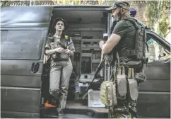  ?? ?? Liana Nigoyan and Annril Borysov, both medics in the
Ukrainian military, wait to deploy out of Bachmut.