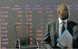  ?? /Reuters ?? On the board: A man stands in front of an electronic board displaying market data at the Nairobi Securities Exchange in Nairobi, Kenya.