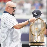  ?? Julio Cortez / Associated Press ?? Former New York Yankees pitcher David Wells puts his hat on the 1998 World Series trophy during a ceremony honoring the team prior to Saturday’s game against the Toronto Blue Jays in New York.