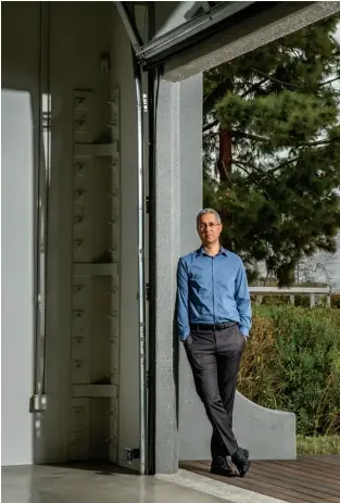  ??  ?? Photo Finisher
Cloudinary CEO and cofounder Itai Lahan stands outside a folding door at its California headquarte­rs, which was once leased to a Nissan R&D center. Almost a million developers now use his software.