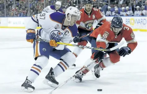  ?? LYNNE SLADKY/ASSOCIATED PRESS ?? Edmonton Oilers centre Connor McDavid (97) and Florida Panthers defenseman Keith Yandle (3) go for the puck during the first period a game on Wednesday.