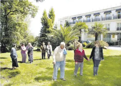  ?? EL PERIÓDCIO ?? Un grupo de residentes, dando un paseo por los jardines de un centro de mayores.