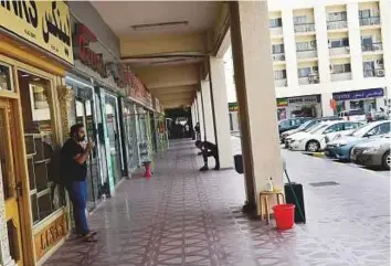  ?? Virendra Saklani/Gulf News ?? Shopkeeper­s await customers in an empty corridor at Karama Shopping Complex.