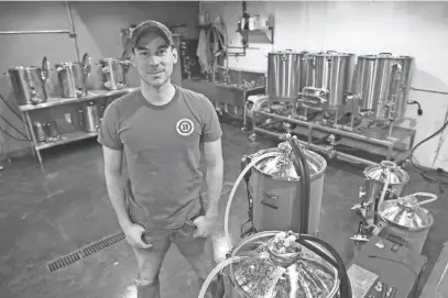  ?? MILWAUKEE JOURNAL SENTINEL FILES ?? Spike Brewing owner Ben Caya displays a test brewery set up at the company in 2019. The company plans to develop a manufactur­ing plant on a nearby city-owned vacant lot.