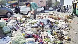  ?? PTI ?? Garbage strewn on the road after sanitation workers’ protests continued on Wednesday