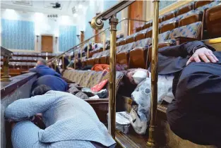  ?? ANDREW HARNIK/ASSOCIATED PRESS ?? People shelter in the House gallery as protesters try to break into the House Chamber. As a precaution, gas masks were handed out to lawmakers and others in the chamber.