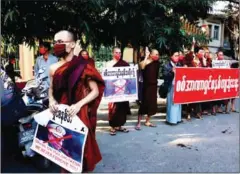  ?? STR/AFP ?? Buddhist monks hold signs with the image of Myanmar military chief Senior General Min Aung Hlaing during a demonstrat­ion against the military coup in Mandalay on Monday.