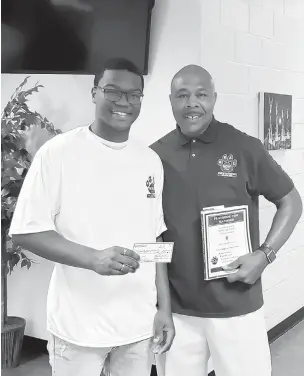  ?? LARRY RUBAMA/STAFF ?? During his coaching career, Cadillac Harris has helped send more than 100 athletes to college. He’s pictured here with Indian River grad Damari Owens, left, who received a $1,000 scholarshi­p from the R.E.A.L. Man Program, sponsored by the Hope Foundation, which Harris is a part of.