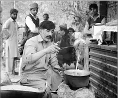  ??  ?? Malik Zafar Iqbal, who runs an union ‘Associatio­n of Kidney Sellers’ (AKS), makes tea for customers at his stall in the town of Kot Momin.